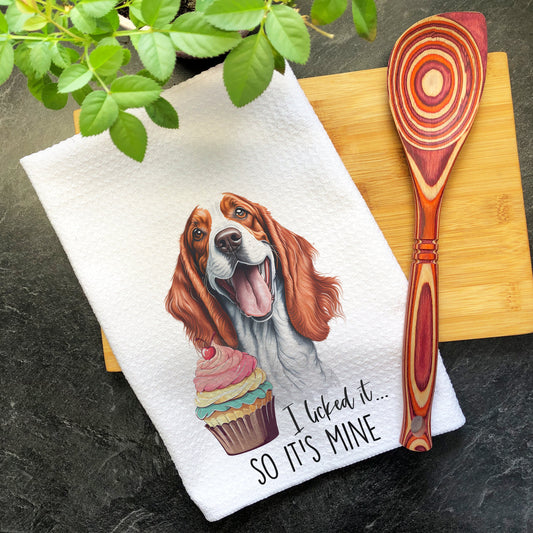 a brown and white dog sitting on top of a wooden cutting board next to a