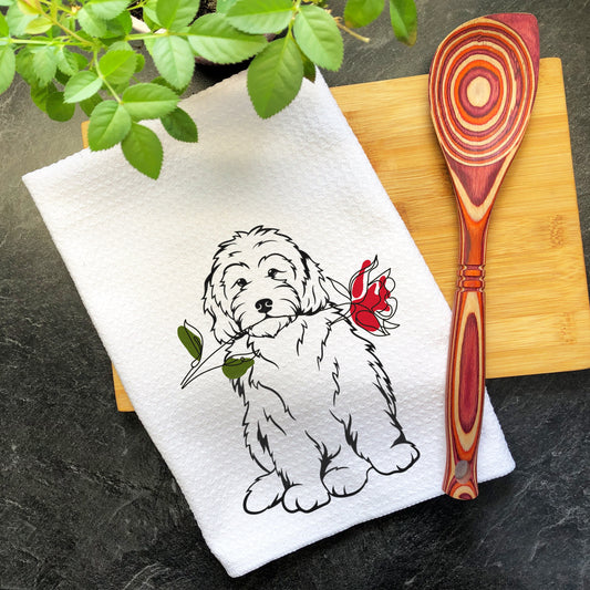 a white dog with a red rose on it&#39;s neck is sitting next to